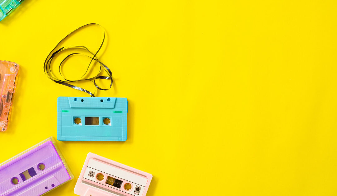 yellow background with blue, purple and pink VHS tapes